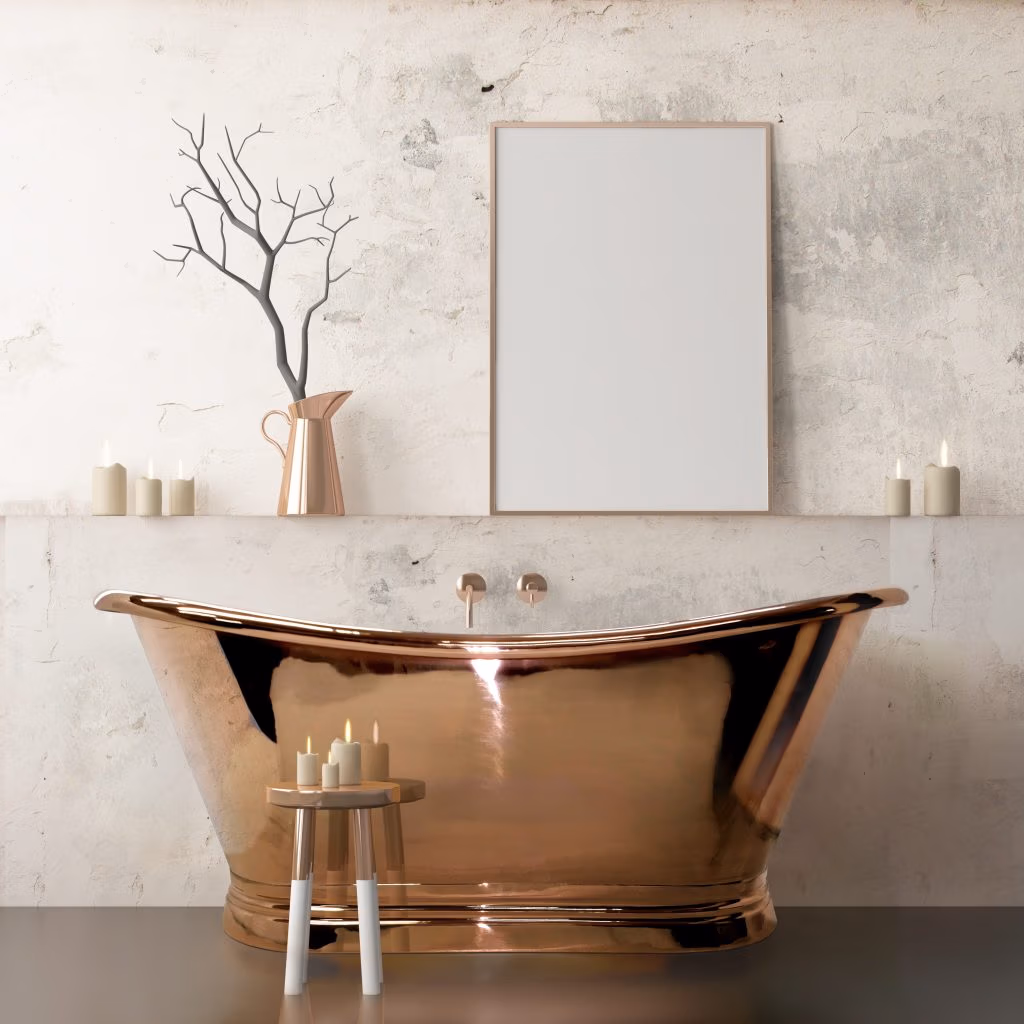 Luxurious bathroom with a shiny copper bathtub, rustic stool with candles, blank framed wall art, ceramic pitcher, and ambient soft lighting.