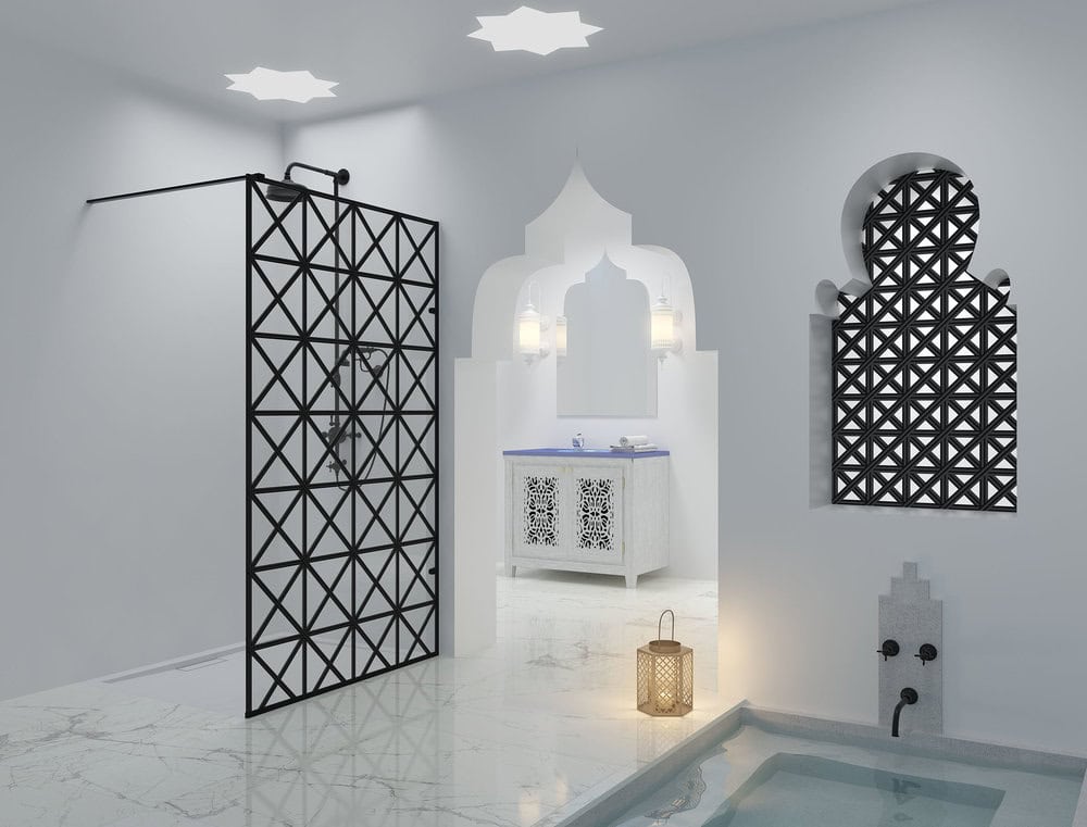 Modern bathroom with ornate Moroccan-inspired decor, featuring geometric patterns, intricate mirrors, a lantern, and a small pool, creating a serene atmosphere.
