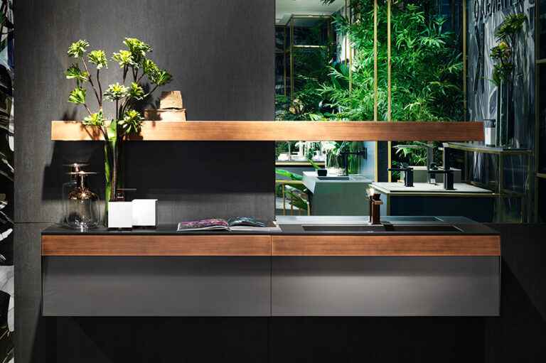 Modern kitchen interior with wooden accents, sleek black cabinets, a vase with green plants, and an open magazine, creating a stylish ambiance.