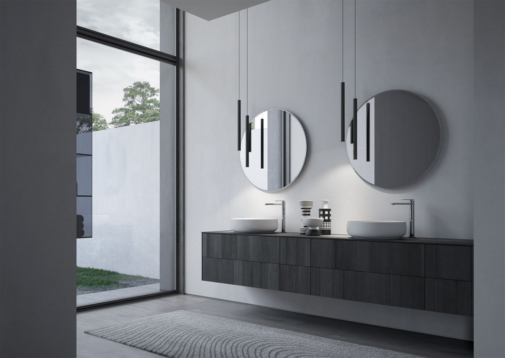 Modern bathroom with dual sinks, round mirrors, and pendant lights. Large window provides natural light, revealing an outdoor view with trees. Minimalist design.