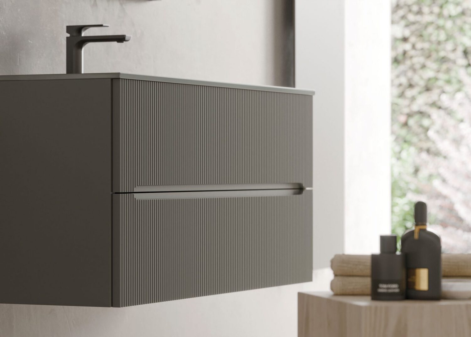 Modern bathroom sink with a striped cabinet, sleek black faucet, and toiletries, including towels and bottles, against a soft, natural background.