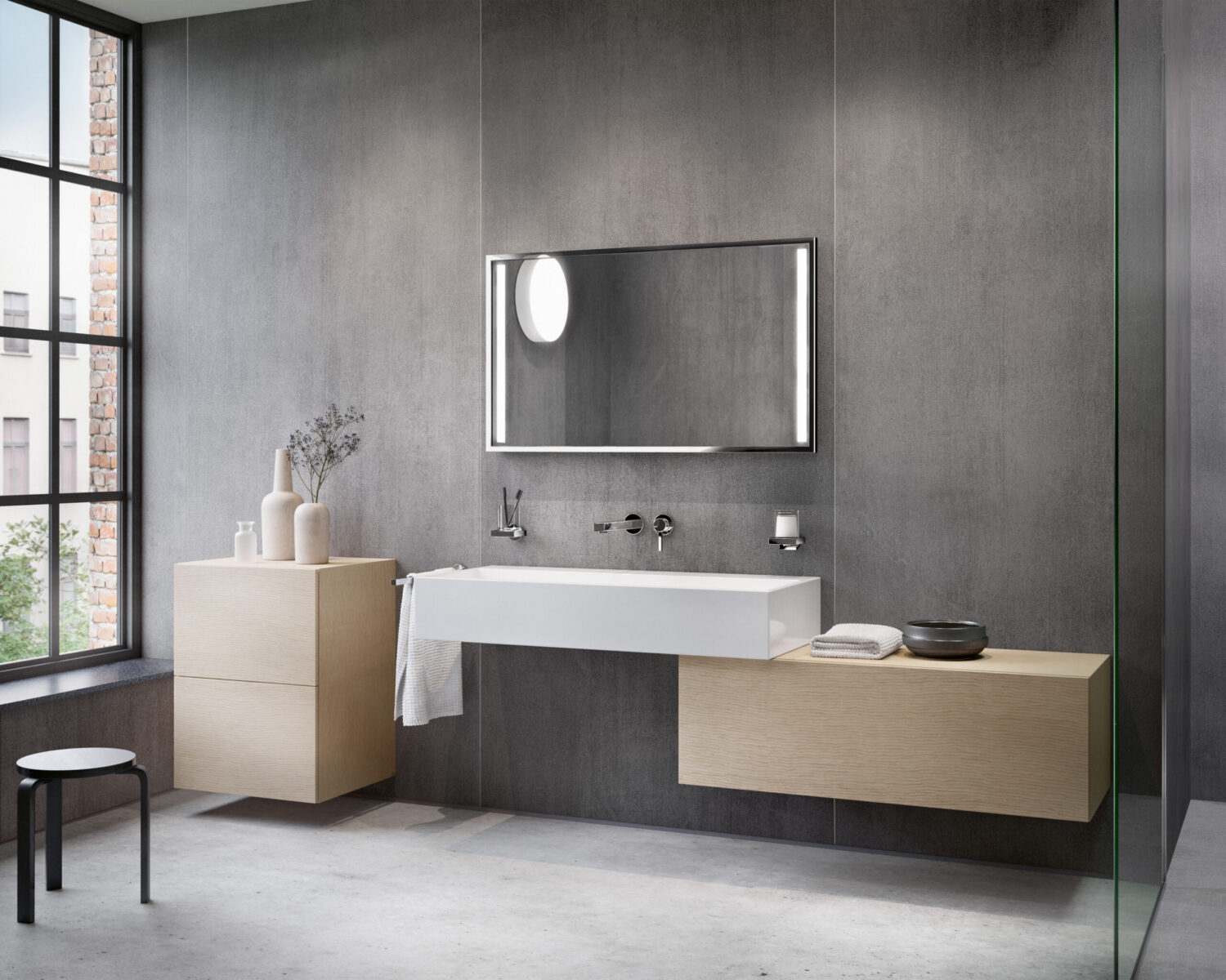 A modern bathroom features sleek gray walls, a large mirror, floating wood cabinets, ceramic vases, and a minimalist stool, enhanced by natural light.