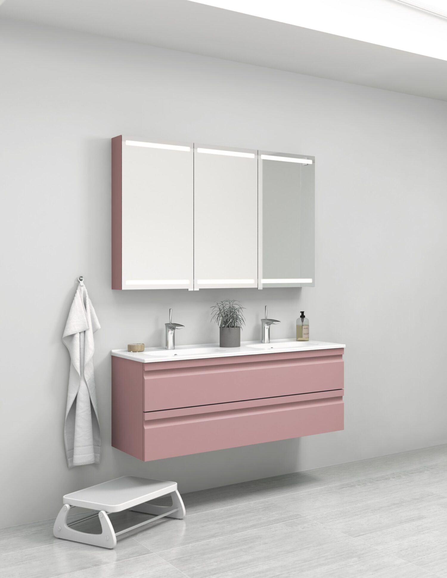 Modern bathroom with pink floating vanity, dual sinks, and mirrors. A towel hangs beside, with a small step stool on the floor.