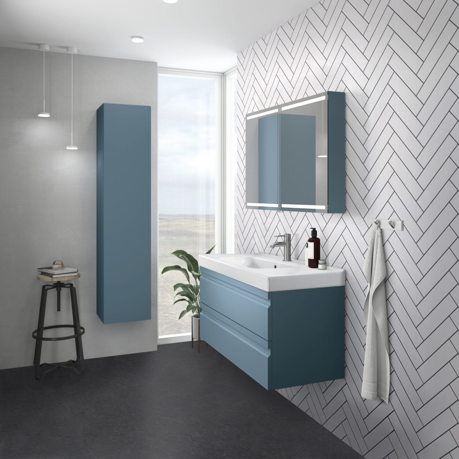 Modern bathroom with blue cabinets, herringbone tile wall, and a stool. A plant sits near a tall window, providing natural light.