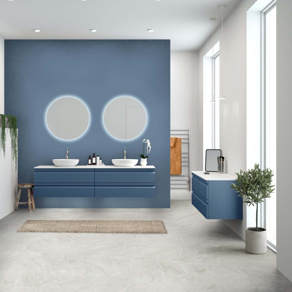 Modern bathroom with dual sinks, round mirrors, and blue cabinets. Features plants, a wooden stool, and a towel rack against a serene color palette.