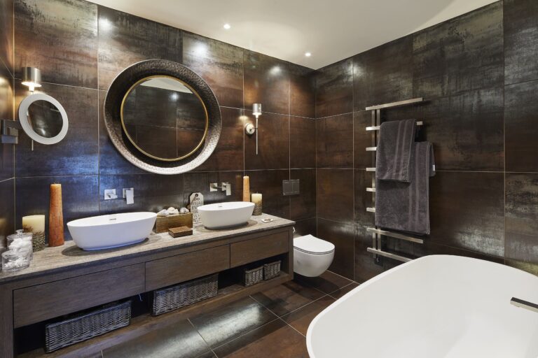 A modern bathroom featuring a large mirror above two stylish sinks, showcasing a sleek and contemporary design.