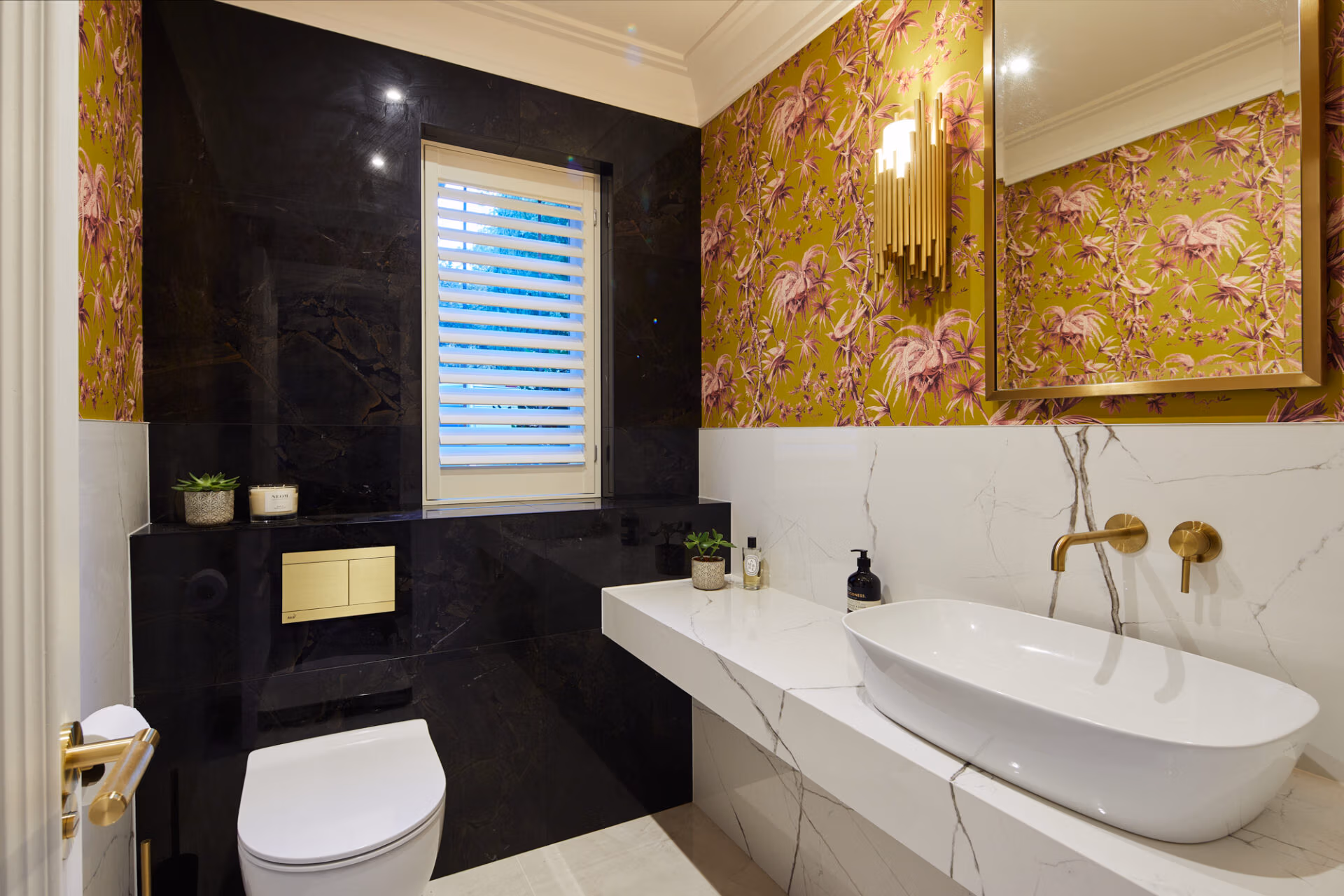A bathroom featuring elegant gold and black floral wallpaper, creating a luxurious and stylish atmosphere.