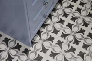The image shows a blue cabinet next to a tiled floor with a black and white floral pattern design.