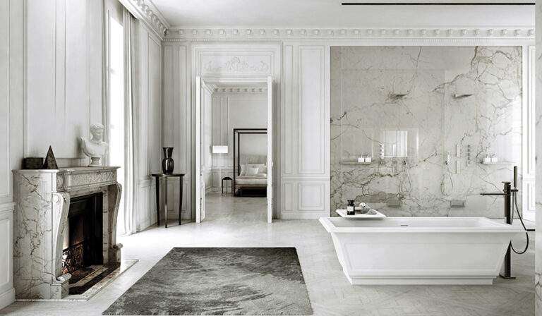 Luxurious bathroom with marble walls, elegant fireplace, standalone bathtub, and bedroom view through open doors; classical, sophisticated interior design.