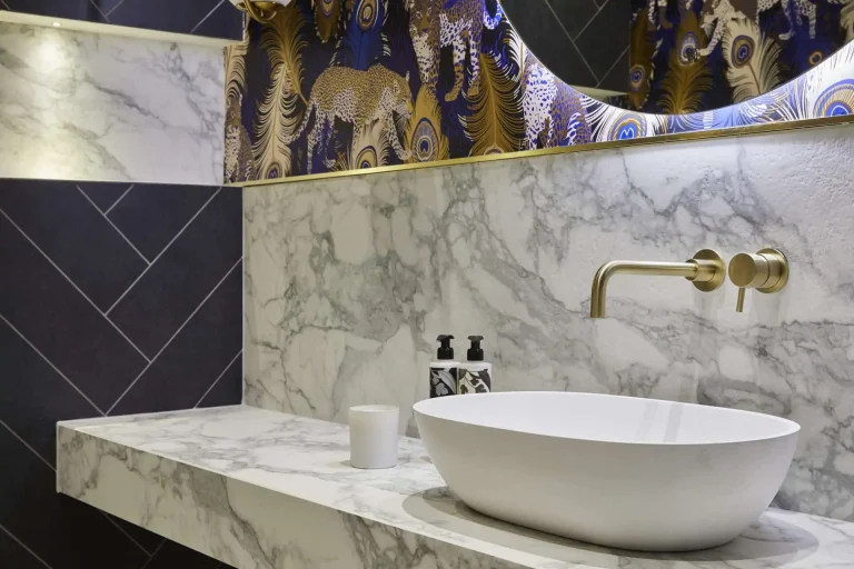 Elegant marble bathroom vanity featuring a vessel sink and stylish gold tap.