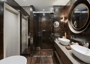 Modern bathroom with walk-in shower, contemporary fixtures, and elegant dark tile design.