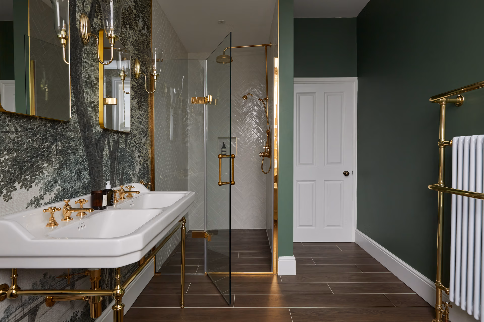 A stylish bathroom with vibrant green walls complemented by luxurious gold fixtures, enhancing its overall elegance.