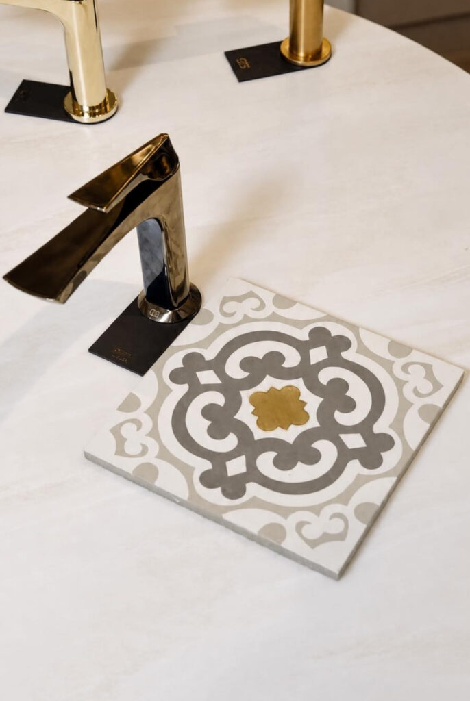 Luxury bathroom tap display at Kallums Bathrooms showroom, featuring elegant patterned ceramic tiles and premium bathroom design inspiration in Putney and Guildford.