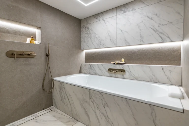 Modern guest bathroom with marble features and a built-in bathtub.