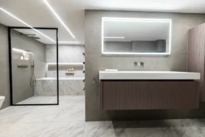 Modern bathroom with walk-in shower, floating vanity, and illuminated mirror.