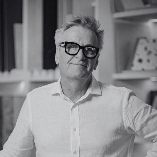 Professional man in glasses and white shirt in modern office setting.