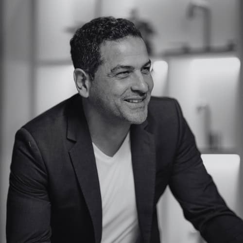 Smiling man in a suit in a professional office setting.