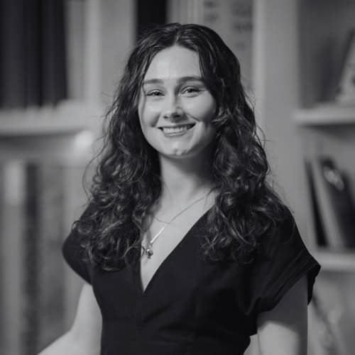Smiling woman with curly hair in a professional setting for Kallums Bathrooms.