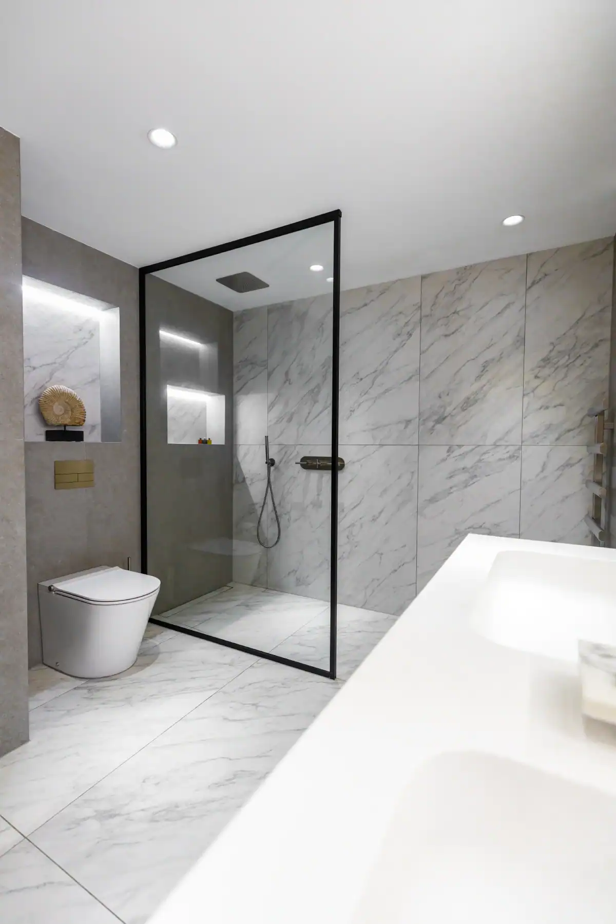 Modern bathroom with marble tiles, walk-in shower, and sleek fixtures in Putney.