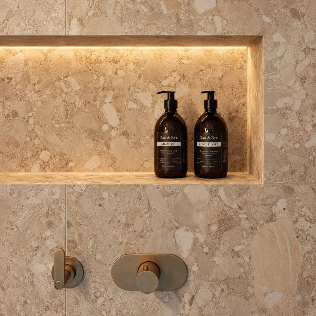 Elegant bathroom shelf with black shampoo and conditioner bottles in a modern shower.