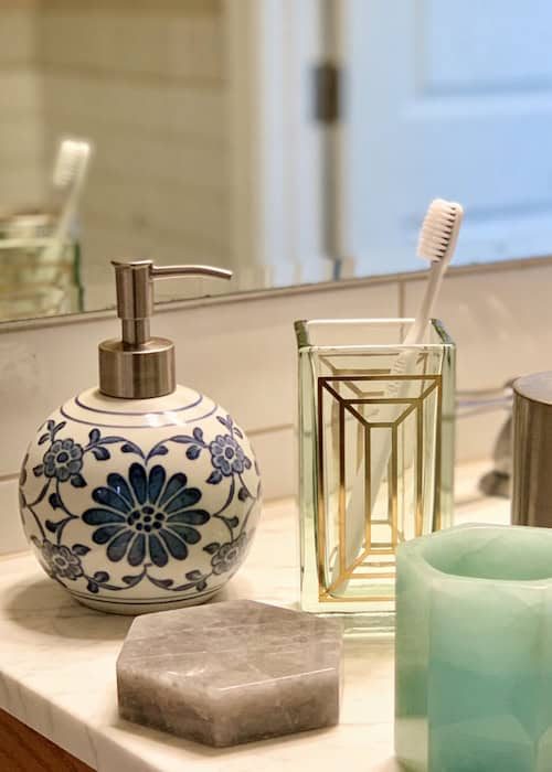 Stylish floral soap dispenser and toothbrush holder for modern bathrooms.