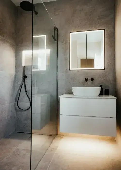 Contemporary bathroom featuring a walk-in shower, sleek vanity, and illuminated mirror for a stylish.
