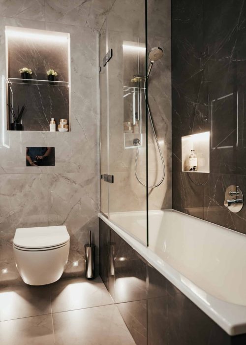 Modern bathroom with walk-in shower, bathtub, and sleek dark and light tiles.
