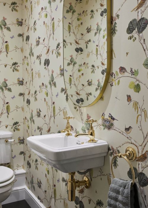 Bathroom with botanical-themed wallpaper featuring birds and foliage.