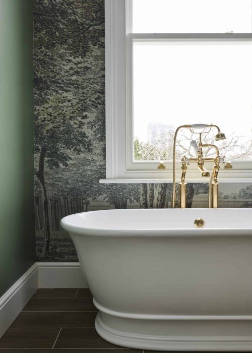 Luxury freestanding bathtub with gold fixtures in a contemporary bathroom.