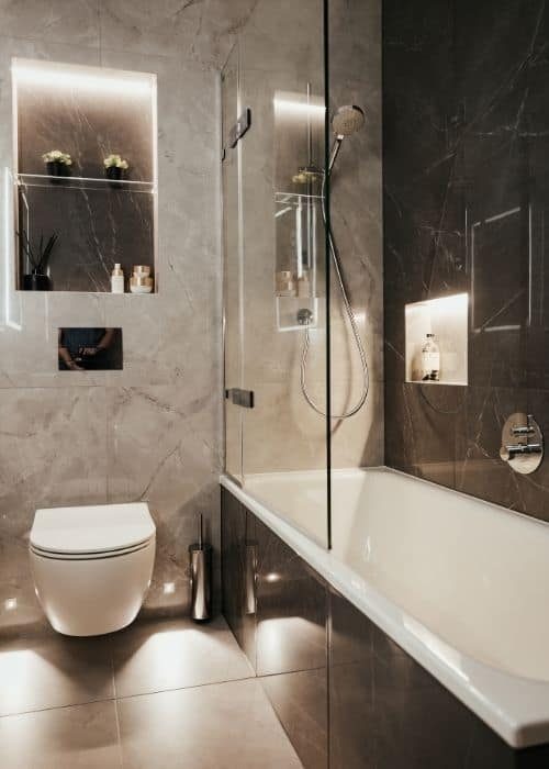 Contemporary grey bathroom with bathtub, walk-in shower, and sleek fixtures.