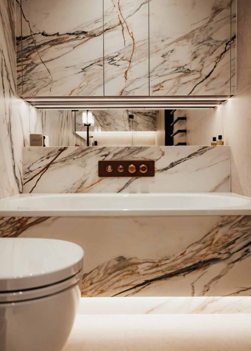 Modern bathroom with marble walls and sleek fixtures for bespoke design.