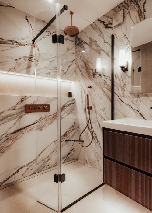 Modern marble bathroom with walk-in shower and wooden vanity unit.