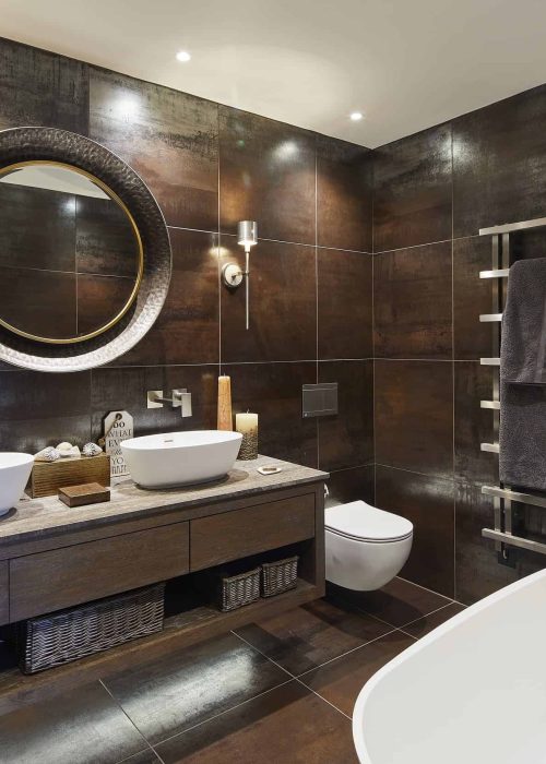 A modern bathroom featuring a large mirror above two stylish sinks, showcasing a sleek and contemporary design.
