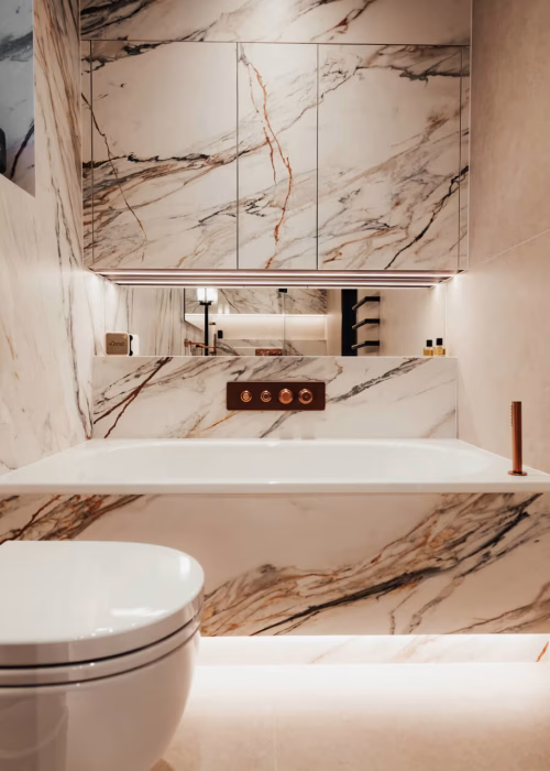 Luxurious bathroom with marble walls and bathtub, glowing ambient lights, modern fixtures, and a sleek monochrome towel warmer, conveying elegance.