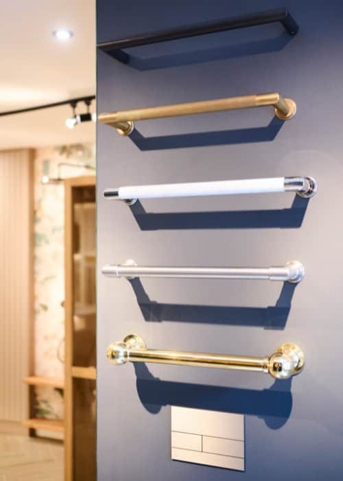 Variety of towel rails in different finishes on a bathroom wall.