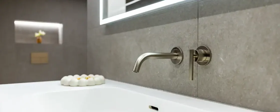 Modern bathroom with wall-mounted faucet and large mirror in a luxury spa-style setting.