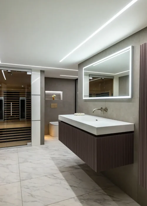 Modern guest bathroom with floating vanity, large mirror, and walk-in shower.