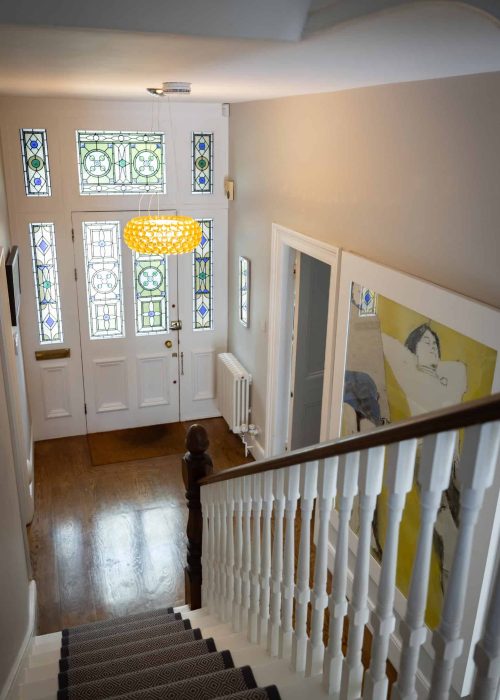 Victorian-style hallway with stained glass windows and staircase in Herne Hill home.