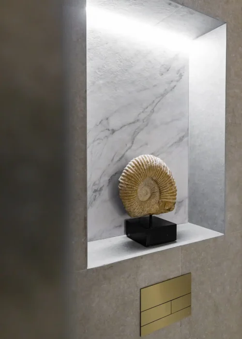 Modern bathroom niche with marble background and decorative shell ornament.