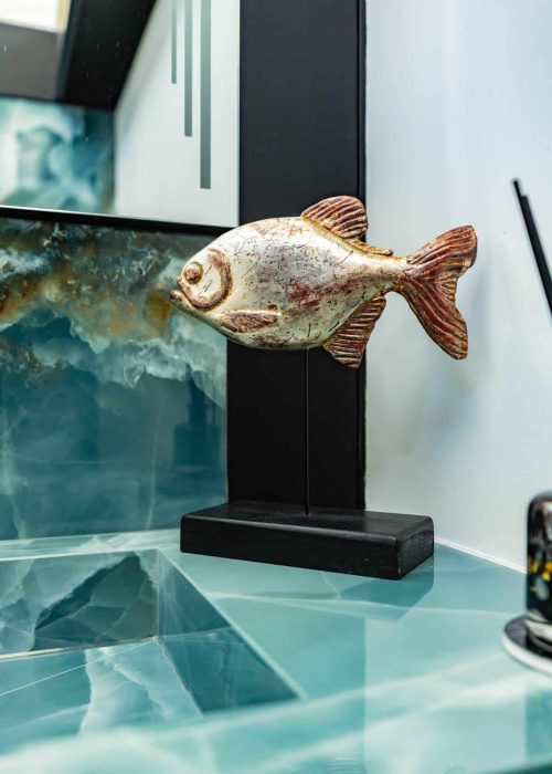 Decorative fish sculpture on bathroom countertop with modern design elements.