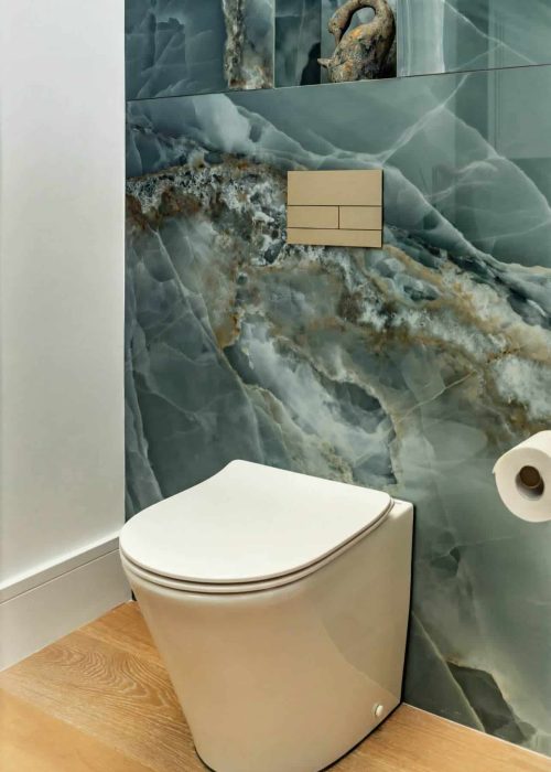 Modern toilet with marble feature wall in a stylish cloakroom.