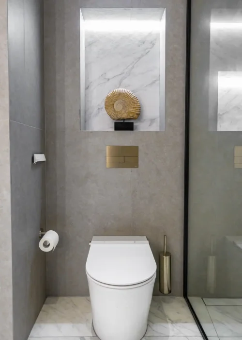 Modern bathroom with marble wall niche and sleek toilet design.