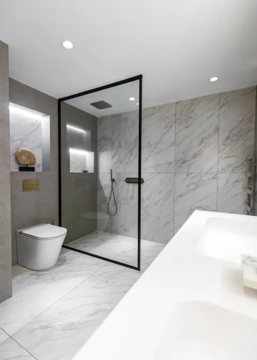 Modern bathroom with marble tiles, walk-in shower, and sleek fixtures in Putney.