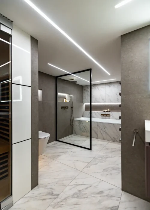 Modern guest bathroom with marble features and glass shower enclosure.