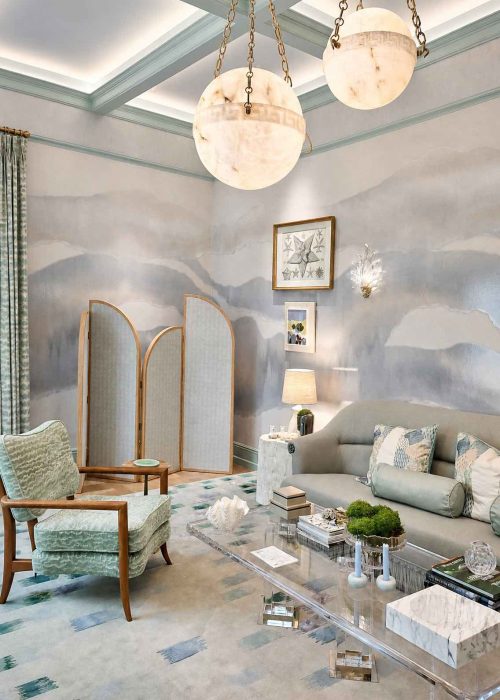 Pair of alabaster globe pendants on brass chains beneath a coffered ceiling in a luxury drawing room at WOW!house 2026