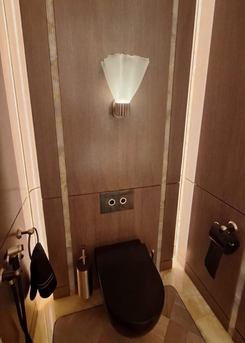Dark wood panelled WC with fan-shaped wall light at WOW!house 2026, Design Centre Chelsea Harbour.