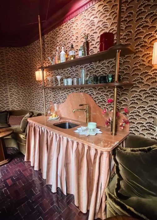 Pink marble basin with gathered linen skirt and brass tap in a classical-inspired room at WOW!house 2026 London