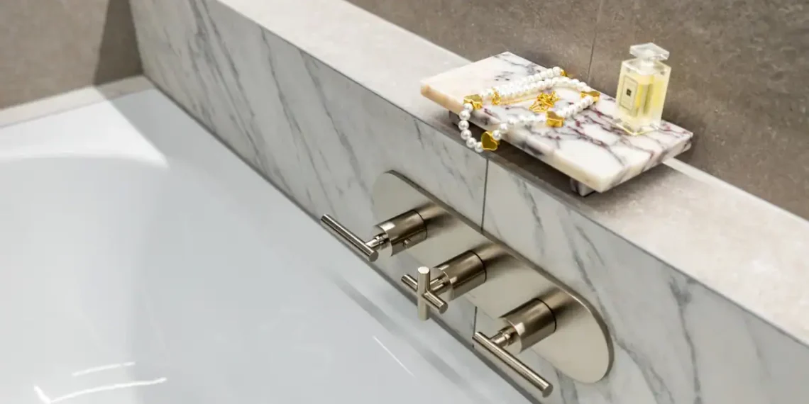 Elegant bathroom with marble shelf, gold accessories, and modern fixtures.